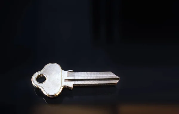Blank metal key on a dark background — Stockfoto