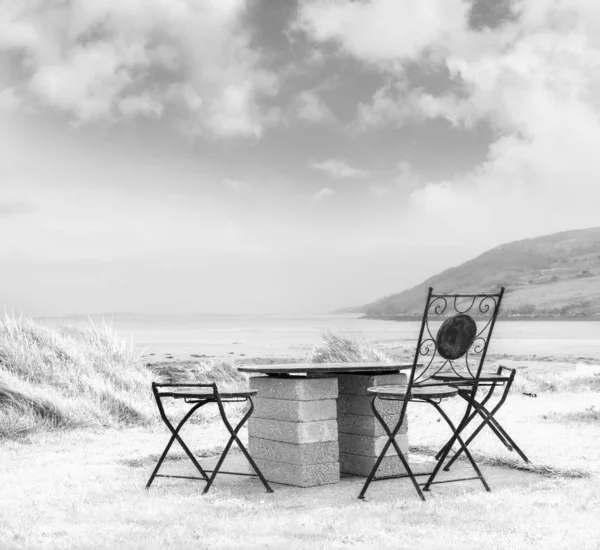 Beautiful white landscape with black chairs and concrete table o