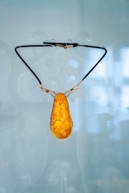 Cam bir rafta kehribar kolye. Kapat..