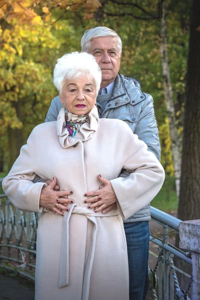 beautiful happy old people sitting in the autumn park