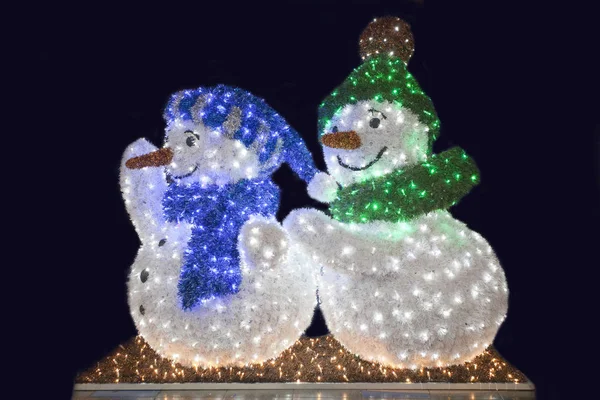 Due divertente pupazzo di neve onda contro nero notte fondo — Foto Stock