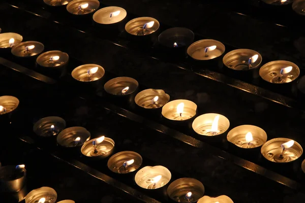 Молится свечи памяти в храме в темноте — стоковое фото