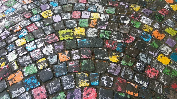 Många färgade målade cobble sten trottoaren i efter regn — Stockfoto