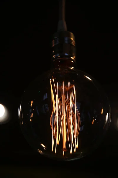 Старовинна вольфрамова лампочка сяє в темряві — стокове фото