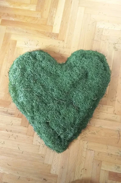 Memories heart of fir pine needles decoration after christmas holiday on the ground at home
