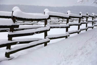 Closeup of snowy corral poles as a winter background clipart