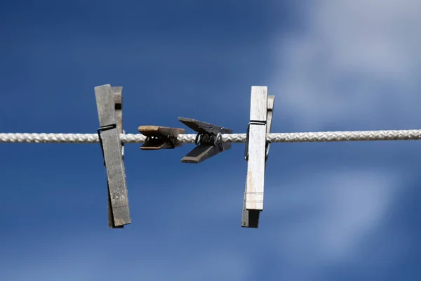 Wäscheklammern hängen an einem Seil vor blauem Himmel Hintergrund — Stockfoto