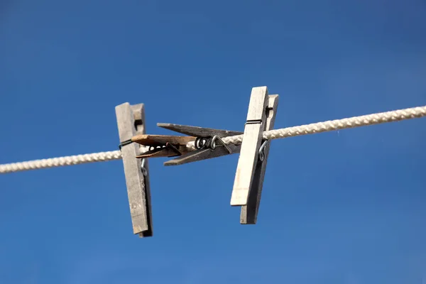 Clothespins hanging on a rope against blue sky background — Stock Photo, Image