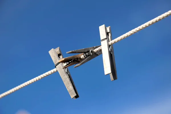 Klädnypor hängande på ett rep mot blå himmel bakgrund — Stockfoto