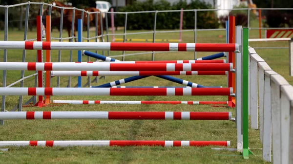 Kleurrijke barrières op de grond voor springpaarden en ruiters — Stockfoto