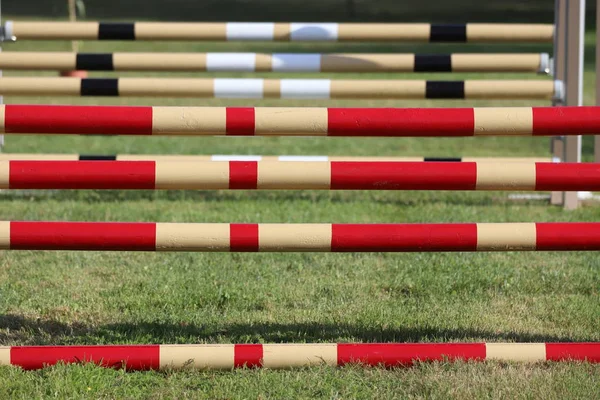 Image of show jumping poles on empty training field.