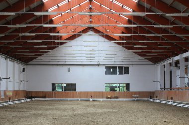 Atlar ve biniciler için boş bir binicilik salonunun manzarası. Binicilik okulu binicilik ve atlama için uygundur.