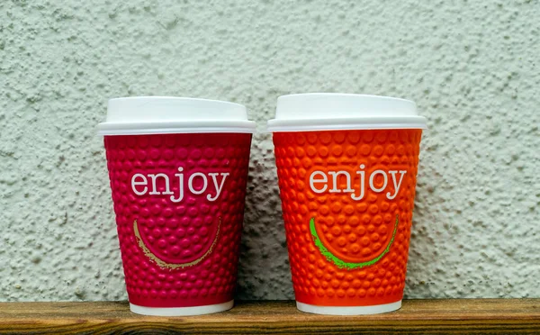 Masanın üzerinde arka planda iki fincan kahve var.