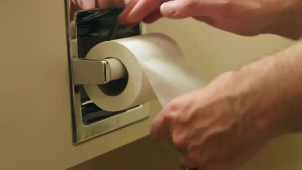 Een man grijpt toiletpapier — Stockvideo