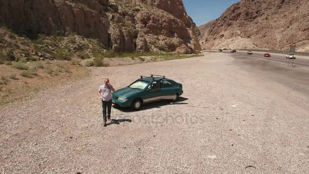 Man zijn drone landing in een woestijn canyon — Stockvideo