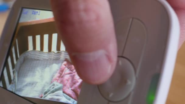 Mann sieht Baby auf Babymonitor an — Stockvideo