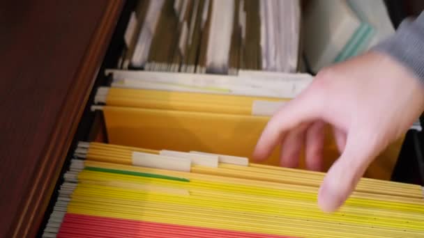 Un hombre abre su archivador y busca un documento en un archivo — Vídeo de stock