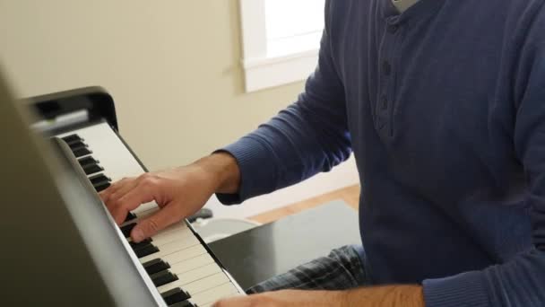 En man som spelar på piano i huset — Stockvideo