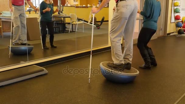 Een man praktijken evenwicht in fysiotherapie — Stockvideo