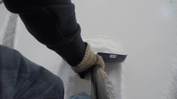 Ένας άνθρωπος φτυάρια το χιόνι από το δρόμο — Αρχείο Βίντεο