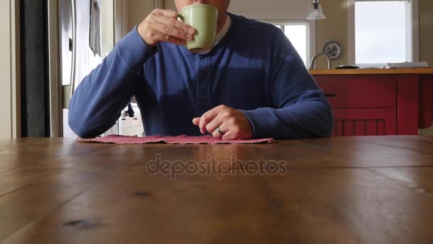 Seorang pria duduk di meja dengan kopi — Stok Video