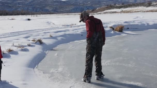 Чоловік тестує силу льоду на ставку — стокове відео