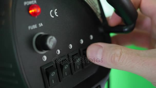 Um homem desliga os interruptores para uma luz de vídeo em um set de filme — Vídeo de Stock