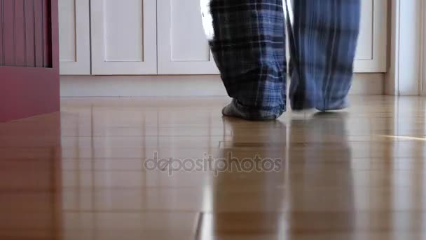 En man fötter gå igenom hans hus — Stockvideo