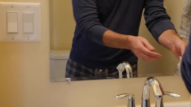 En man tvättar händerna i badrummet — Stockvideo