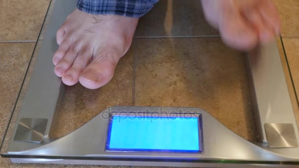 Man steps on the scale to weigh himself — Stock Video