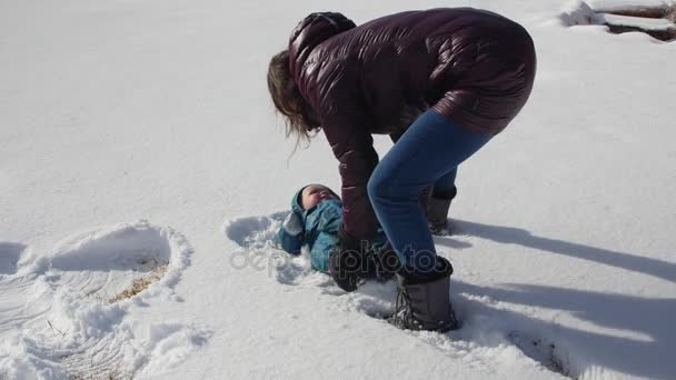 Una madre e un bambino fanno un angelo di neve — Video Stock