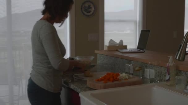 Una madre cortando verduras en la cocina para la cena — Vídeo de stock