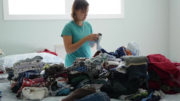 A mother sorts through the kids clothes — Stock Video