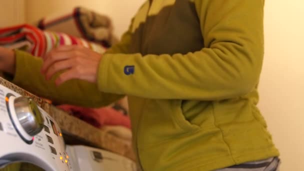 Une maman fatiguée plie une pile de linge — Video