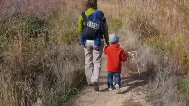 女性と男の子が庭の道でハイキング — ストック動画