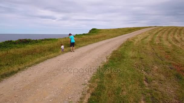 Mother and baby walking along ocean coast — Stock Video