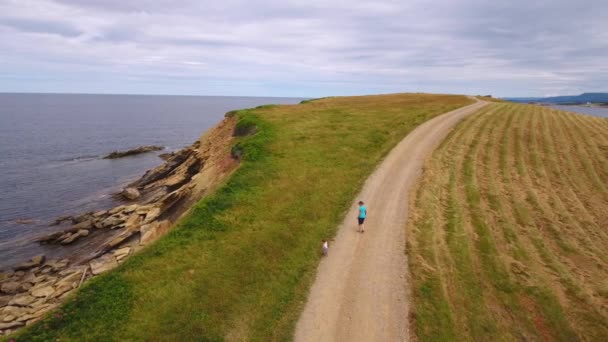 Mor och hennes barn promenader längs havet kusten — Stockvideo