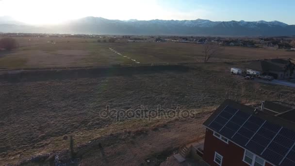 Дом с солнечными панелями и горы на закате — стоковое видео