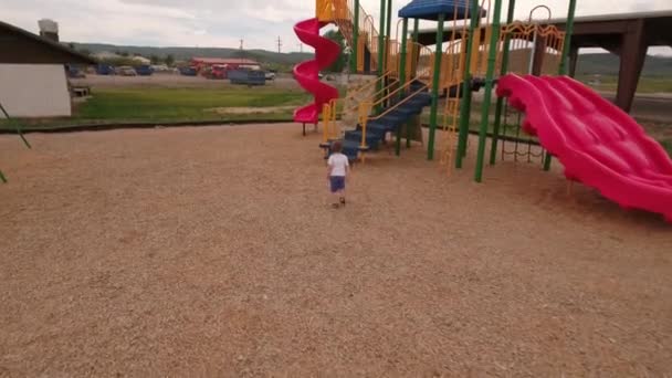 Petit enfant jouant sur un parc municipal — Video