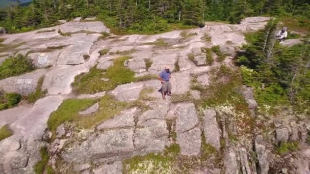 Hombre de pie en la cima de un acantilado sobre un cañón forestal — Vídeos de Stock