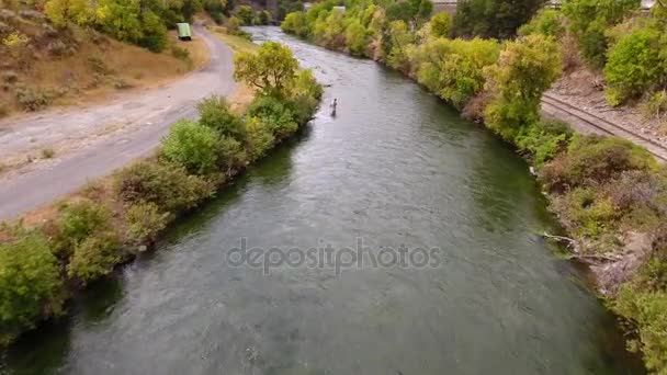 Man fishing in the Provo river near a road — Stock Video