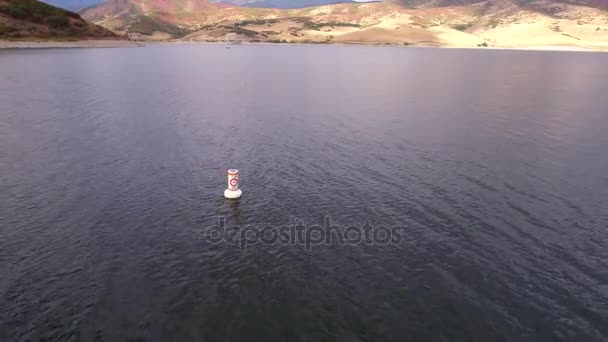 Boei drijvend op lake shore water — Stockvideo