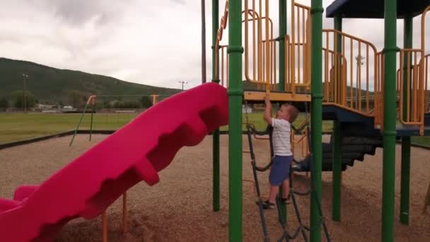 Мальчик играет в городском парке — стоковое видео