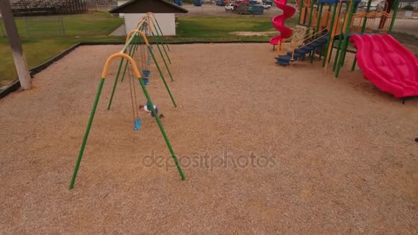 Chico jugando en el parque de la ciudad swing — Vídeos de Stock