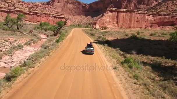 Автомобиль, путешествующий по пустынному каньону — стоковое видео