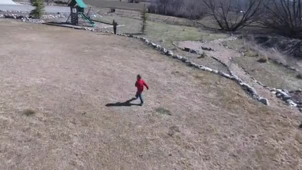 Pojke som löper över gräset — Stockvideo