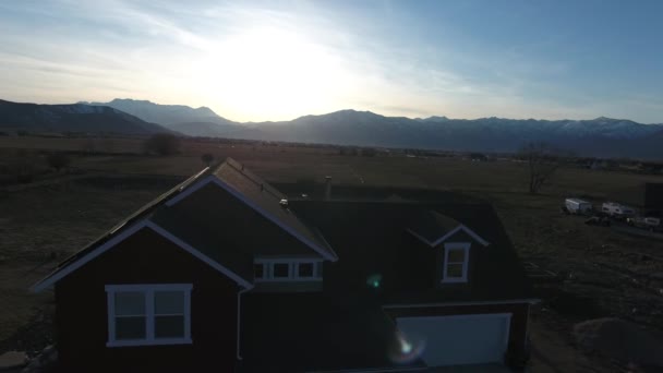 Huis met zonne- en bergen bij zonsondergang — Stockvideo