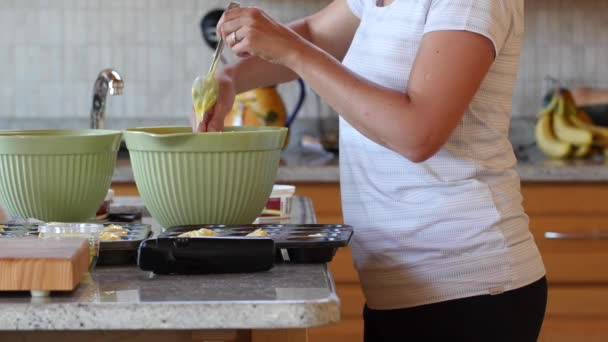 女性は、台所でカップケーキを作る — ストック動画