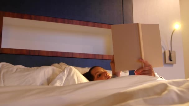 Une femme lisant son livre dans un lit doux — Video