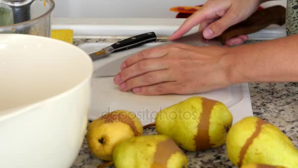 Een vrouw snijden peren in de keuken — Stockvideo